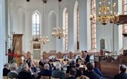 Deelnemers aan de preektocht luisteren naar college 2, door prof. dr. M.A. van Willigen, in de Grote of Sint-Martinuskerk in Dokkum. beeld Bastiaan van Soest