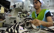 Een vrouw werkt in een kledingfabriek in Bangladesh. Veel ondernemingen hebben hun productieproces uit winstoogpunt verplaatst naar lagelonenlanden. beeld AFP, Munir uz Zaman