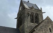 Een parachutist bleef hangen aan de kerktoren van Sainte-Mère-Église. beeld RD