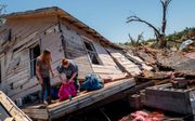 De familie Crowder uit Oklahoma verzamelt bezittingen nadat hun huis totaal is verwoest door een tornado, begin mei. Afgelopen weekend was het opnieuw raak in diverse staten. beeld AFP, Brandon Bell