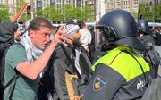 Met verhitte hoofden intimideren pro-Palestijnse demonstranten ME’er Mark (r.) tijdens een SGP-solidariteitsactie voor Israël en de Joodse gemeenschap op de Dam in Amsterdam. beeld RD