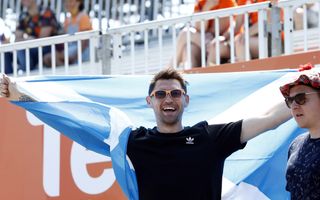 Een man houdt met beide armen een Schotse vlag omhoog. beeld ANP, Willem Vernes