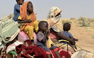 Sudanees vluchtelingengezin in woestijnachtig gebied.