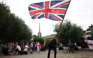 Een demonstrant zwaait met een Britse vlag.