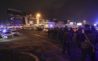 Russische politiemensen arriveren bij de concertzaal waar terroristen tientallen mensen doodschoten. beeld EPA, Maxim Shipenkov
