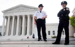Agenten in uniform voor een gebouw met een zuilengalerij