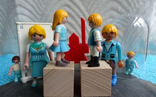Playmobilpoppetjes bij houten blokjes. 