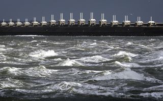 Woelig water, waterkering en donkere lucht.