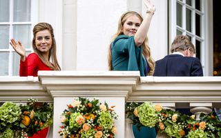 De prinsessen zwaaien en glimlachen terwijl ze het paleis weer in gaan. Hun vader is nog net te zien.