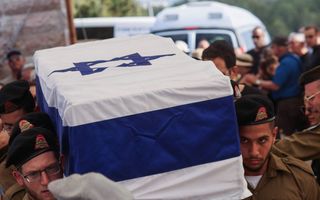 Soldaten met baretten op dragen een lijkkist met daarop de blauw-witte vlag van Israël.