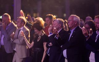 Zwijgende mensen houden kaarsjes omhoog.