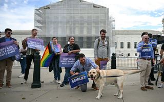 Demonstranten protesteren met borden voor een gebouw 