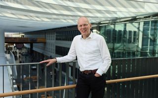 Man in wit overhemd op een loopbrug.