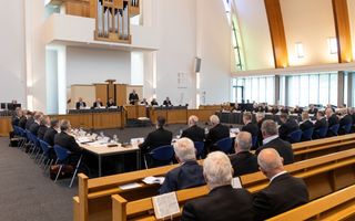 Luisterende mannen in kerkzaal.