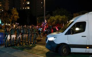 Soldaten salueren ’s avonds voor een wit bestelbusje. 