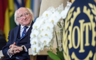 Man in pak met wit, lang haar op de slapen.