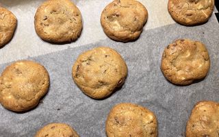 Koekjes op een bakplaat die is bekleed met wit bakpapier.