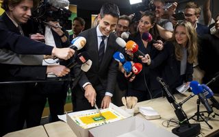 Rob Jetten snijdt taart aan, om hem heen journalisten