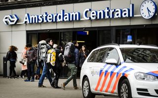Politieauto voor de ingang van het stationsgebouw Amsterdam Centraal.