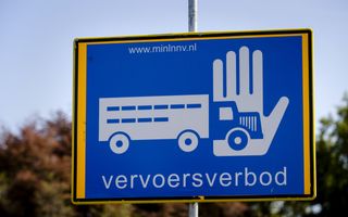 Een blauw bord met daarop een gestileerde vrachtwagen, een hand die hem tegenhoudt en de tekst ”vervoersverbod”.