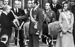 Man in uniform legt vingertoppen op boek dat voor hem wordt gehouden.