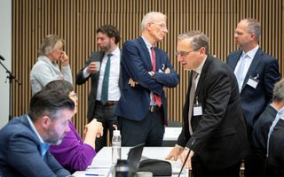 Mannen en vrouwen met elkaar in gesprek, de meesten staand.