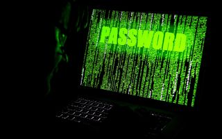 Een donkere kamer met daarin een laptopscherm en daarop een groene brij van letters en tekst en de vraag om een wachtwoord.