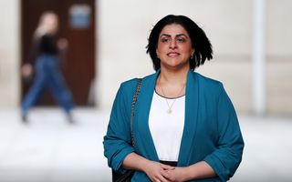 Vrouw met donker haar en blauw jasje.