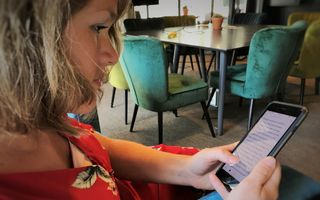 Een vrouw leest de Bijbel op haar telefoon.