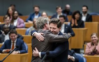 Twee mannen geven elkaar een vriendschappelijke omhelzing.