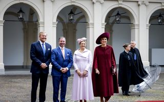 Het Nederlandse koningspaar en het groothertogelijk paar van Luxemburg, op een plein. Op de achtergrond zuilen en bogen.