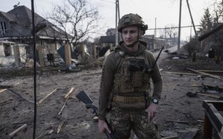 Een militair staat in een verwoeste stad. 