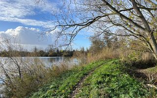 Smal onverhard pad langs een meertje.