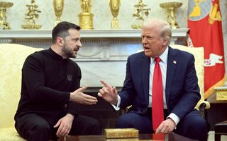 Zelensky, in zwarte trui en broek, zit tegenover in pak gestoken Trump, beiden maken gebaren waaruit duidelijk blijkt dat ze het oneens zijn. 