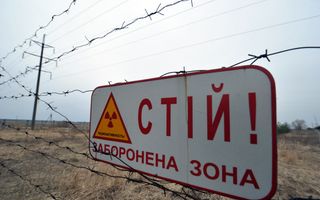 Bord aan prikkeldraad waarschuwt voor radioactiviteit. 