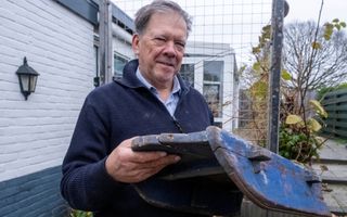 Man in blauwe trui, met oud sleetje.