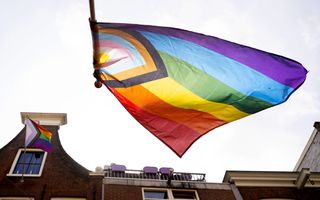 Een regenboogvlag wappert in de wind.