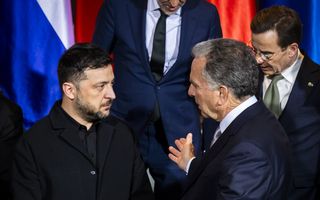 Twee mannen in donkere kleding praten met elkaar.