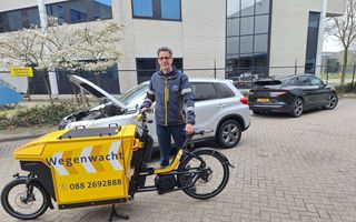 Wegenwacht Martin van Wijk met elektrische bakfiets naast een auto met pech. beeld ANWB