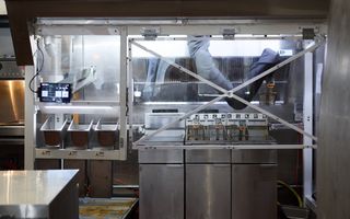 Een AI-robot maakt frietjes in de keuken van een restaurant in Pasadena, Californië (VS). beeld EPA, Allison Dinner