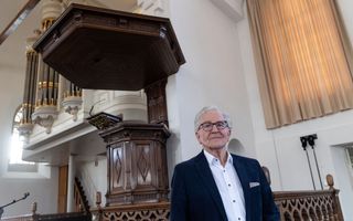 Evert de Graaf bij de 400 jaar oude preekstoel van de Oude Kerk in Putten. beeld RD, Anton Dommerholt
