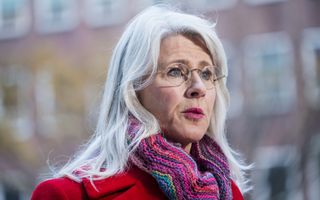 Minister Keijzer in rode jas en met kleurige sjaal.