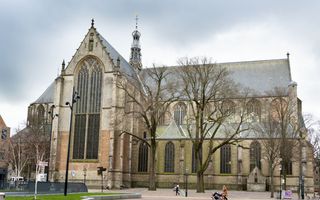 Monumentaal kerkgebouw, met hoge ramen. In het midden een torentje.
