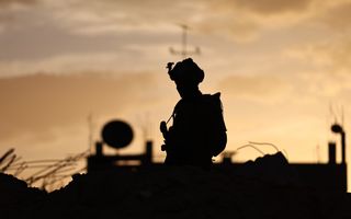 Silhouet van een man met een helm en een geweer.