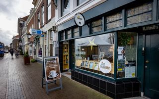 historisch pand met een glazen pui met letters erop.