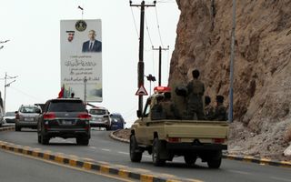 Auto’s rijden langs een spandoek.