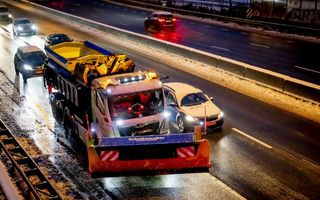 Besneeuwde auto haalt sneeuwschuiver in.