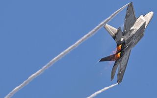 Condenssporen in de lucht achter een straaljager. 