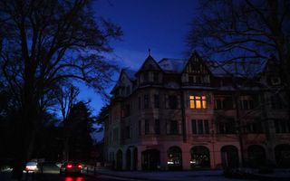 Gebouw in het donker waarbij achter een raam licht brandt. 