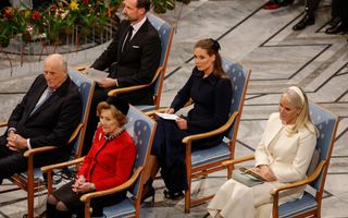Vijf mensen op lichtblauwe stoelen.